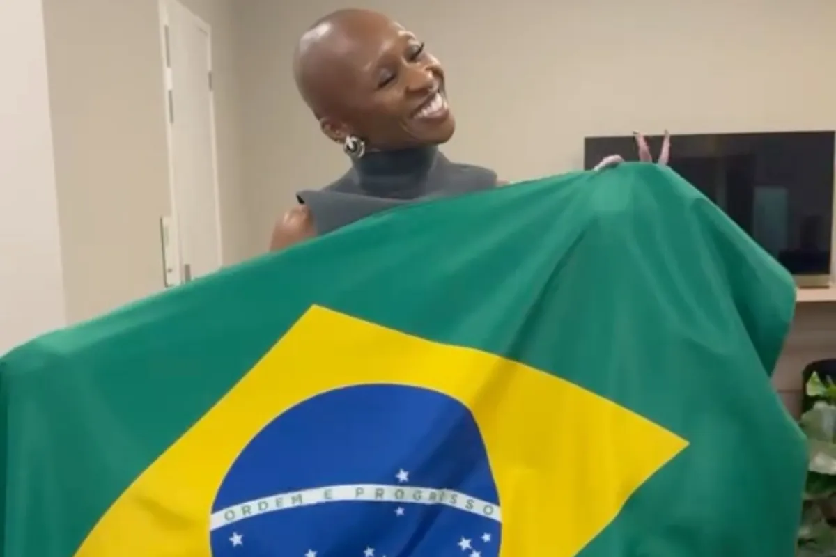 Cynthia Erivo segurando a bandeira do Brasil durante um evento musical