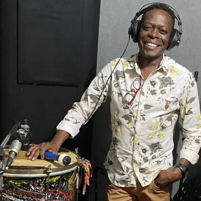 Imagem da Rádio Estação Plus com Morre-Binho tocando percussão